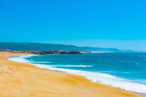 Folk njuter av en solig dag på en strand i Nazare i Portugal — Stockfoto