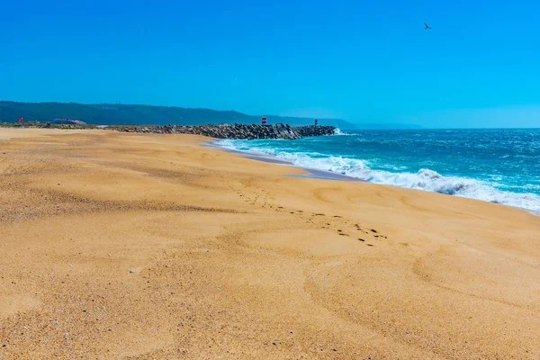 Les gens profitent d'une journée ensoleillée sur une plage à Nazare au Portugal — Photo