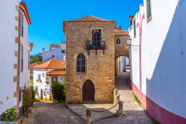a narrow street inside of the obidos castle in Portugal clipart