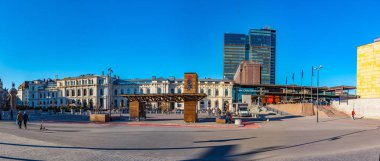 Oslo, Norveç, 15 Nisan 2019: İnsanlar Oslo, Norveç 'teki tren istasyonunun önündeki bir meydanda geziniyor