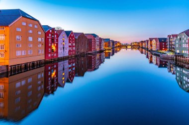 TRONDHEIM, NORWAY, APRIL 15, 2019: Sunset view of colorful timbe clipart