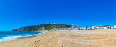 Nazare, Portekiz, 28 Mayıs 2019: İnsanlar Portekiz 'deki Nazare plajında güneşli bir günün tadını çıkarıyorlar