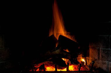 Fireplace lit and vigorous flames rise