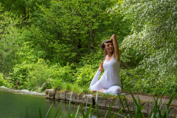 Flicka i vit gör yoga — Stockfoto