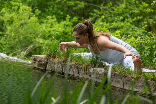 Pige i hvid laver yoga - Stock-foto