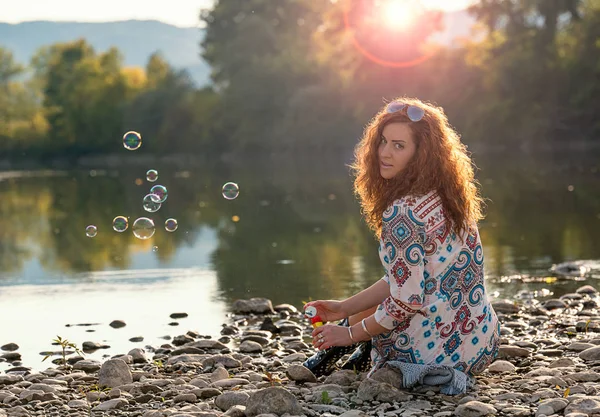 Красивая девушка делает мыльные пузыри — стоковое фото