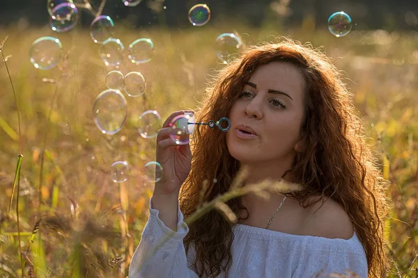 Красивая девушка делает мыльные пузыри — стоковое фото