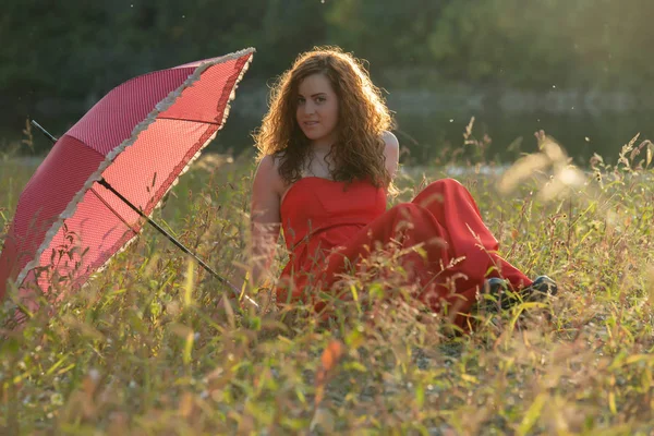 Red - haired meisje in een rode jurk — Stockfoto