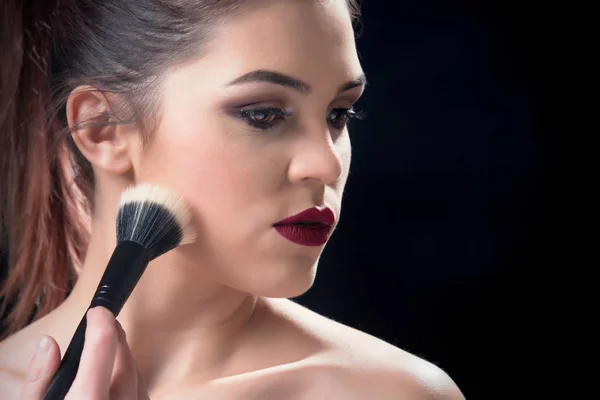 Chica sosteniendo cepillo de maquillaje en la mano — Foto de Stock