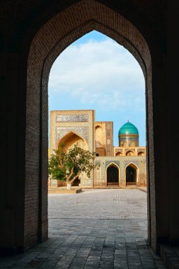 Kalan minaresinin etrafında bulunan İslam dini kompleksi Po-i-Kalyan 'ın iç avlusundaki kemerden medresenin görüntüsü. Buhara. Özbekistan