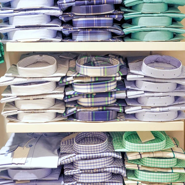 Stapel von männlichen formalen blauen und grünen Hemden in den Regalen der Kaufhäuser, in Großaufnahme — Stockfoto