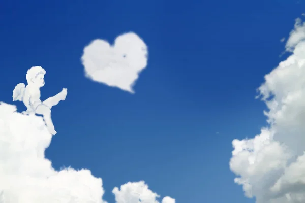 Small angel plays a cloud in form of heart — ストック写真