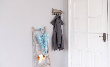 Gri duvarı ve beyaz kapısı olan bir giriş salonu.