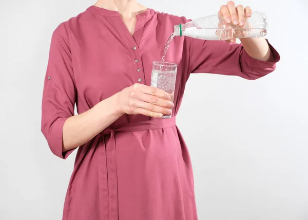 Mujer embarazada vierte agua potable en un vaso —  Fotos de Stock