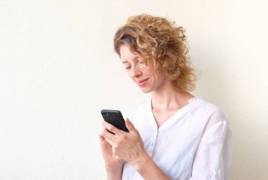  Telefonla iletişim kuran mutlu genç kadın.