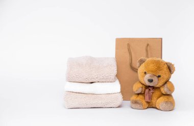 Oyuncak ayı ve bir yığın temiz ve taze pamuk havlu; beyaz arka plan