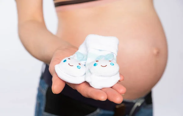 Schwangere Hält Kleine Socken Auf Dem Hintergrund Des Bauches Nahaufnahme — Stockfoto