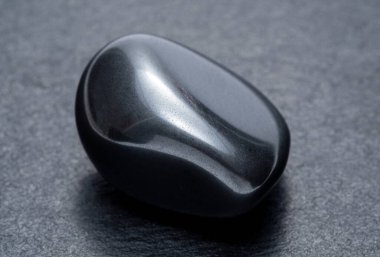 Karanlık bir arka planda siyah obsidian