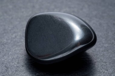 Karanlık bir arka planda siyah obsidian
