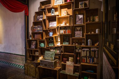 Eşsiz boyutlarda ahşap kitaplık her türlü eski tip ekran eşyalarıyla dolu.