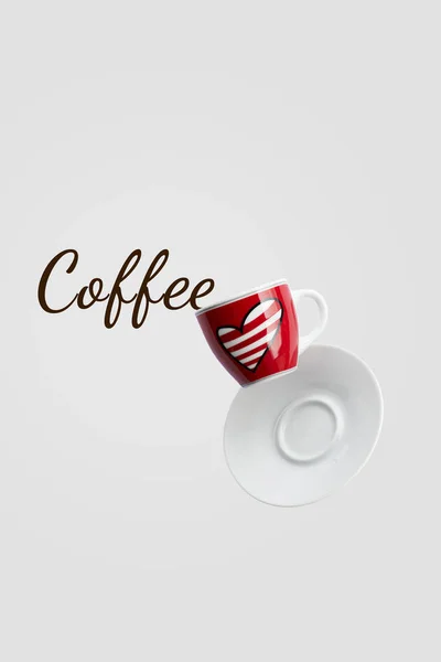 Coffee text spilled out red cup with heart levitation in the air on grey background, holiday layout for your design, copy space, closeup, love cafe creative concept