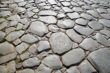 Orijinal kaldırım taşının bir parçası. Antik Roma tarafından inşa edilmiş zaman aşınmış taşlar. Geçmişi. Şablon. Gri.