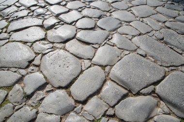 Orijinal kaldırım taşının bir parçası. Antik Roma tarafından inşa edilmiş zaman aşınmış taşlar. Geçmişi. Şablon. Gri.