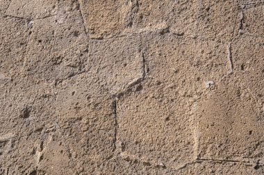 İşlenmiş kumtaşından yapılmış eski bir Roma tapınağının eski bir taş duvarının parçası. Geçmişi. Ocher 'in rengi.