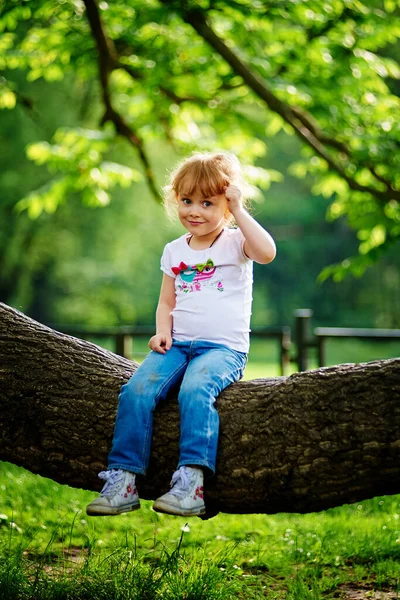 Liten Flicka Sitter Ett Träd Och Skrattar — Stockfoto