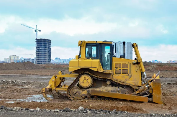 Bulldozer during of large construction jobs at building site. Land clearing, grading, pool excavation, utility trenching and foundation digging. Crawler tractor,  dozer, earth-moving equipment.