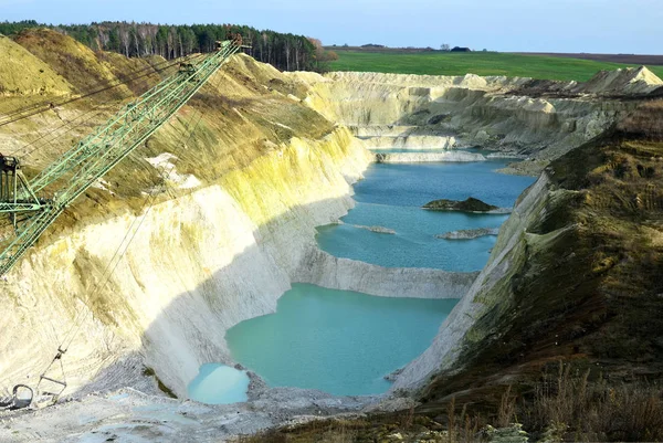 Chalk mining in an industrial quarry at Krasnoselsky village in the Belarus. Mountain lake or river with a turquoise or blue tint of water in a rock canyon.  Turquoise background of the clear river