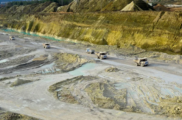 Big yellow mining trucks working in the limestone open-pit. Loading and transportation of minerals in the chalk open-pit. Belarus, Krasnoselsk, in the largest i chalk deposit, quarry \