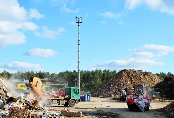 Garbage truck unloads construction waste from container at the landfill. Industrial waste treatment processing plant. Recycling waste concrete  and demolition material