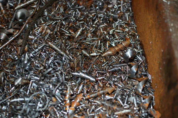 Steel scrap materials recycling. Aluminum chip waste after machining metal parts on a cnc lathe. Closeup twisted spiral steel shavings. Small roughness sharpness, possible granularity, blurred focus