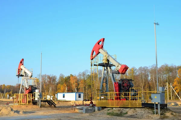 Oil drilling derricks at desert oilfield for fossil fuels output and crude oil production from the ground. Oil drill rig and pump jack.