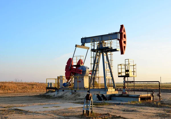 Oil drilling derricks at desert oilfield for fossil fuels output and crude oil production from the ground. Oil drill rig and pump jack.