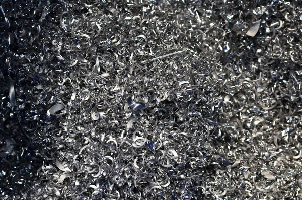 Steel scrap materials recycling. Abstract, background and texture of metal shavings. Aluminum chip waste after machining metal parts on a cnc lathe