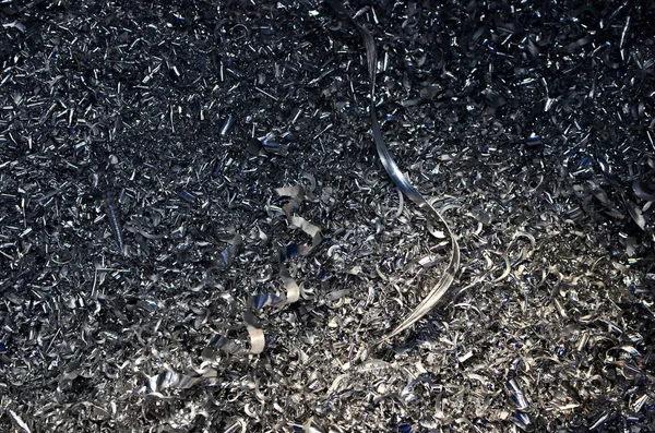 Steel scrap materials recycling. Abstract, background and texture of metal shavings. Aluminum chip waste after machining metal parts on a cnc lathe