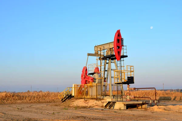 Oil drilling derricks at desert oilfield for fossil fuels output and crude oil production from the ground. Oil drill rig and pump jack.