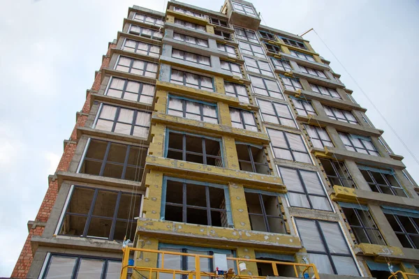 Mineral wool insulation of the facade building on construction site. Insulation for thermal protection to the shell of the house. Installation of double-glazed windows with uPVC frames
