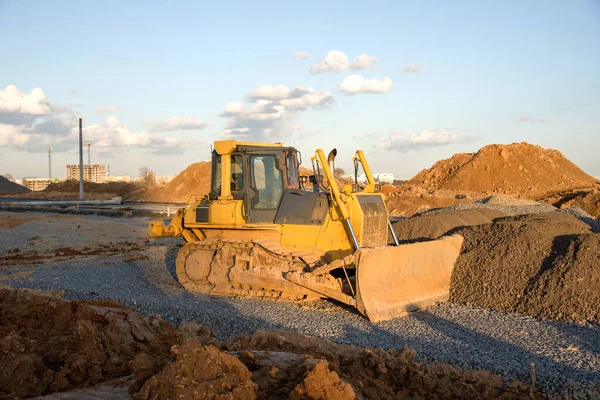Dozer working at construction site. Bulldozer for land clearing, grading, pool excavation, utility trenching and foundation digging. Crawler tractor and earth-moving equipment
