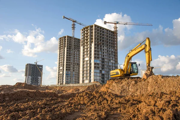 Excavator during Earthmoving Works at construction site. Backhoe digs the foundations of the building and for paving out sewer line. Construction machinery for excavating, loading, lifting and hauling