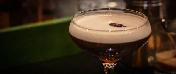 Wide picture of Espresso Martini cocktail with coffee beans garnish; could be used for menu or text on the side