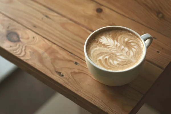 Ahşap masada bir fincan kahve.