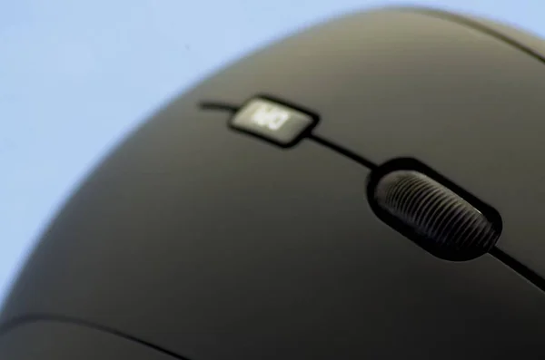 Ergonomic black mouse detail view on blue background