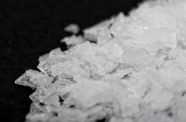 Siyah arka plan makrofotografı üzerine hafif çözünürlüklü Maldon tuzu. Saflık.