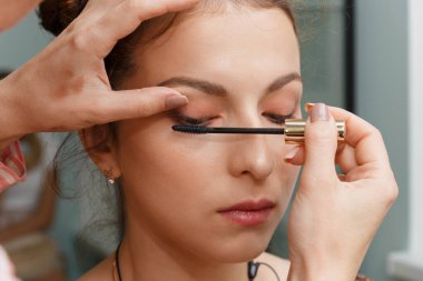 Makyöz, modelin şehvetli kirpiklerini oluşturuyor..