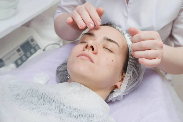 Um cosmetologista faz uma limpeza ultrassônica da pele do rosto . — Fotografia de Stock