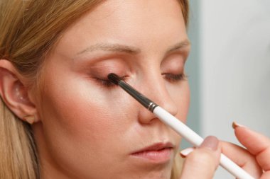 Makyaj yapma süreci. Makyaj sanatçısı bir bru ile çalışıyor