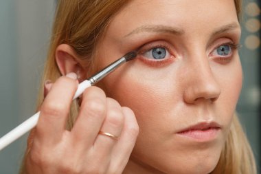 Makyaj yapma süreci. Makyaj sanatçısı bir bru ile çalışıyor